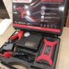 High-Power Jump Starter Kit with LED light, USB ports, air compressor, and cables in carry case.